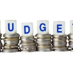 Stacks of coins with the word BUDGET isolated on white background
