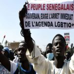 A man holds a sign reading 'No to LGBT agenda' during a protest called by religious associations against homosexuality on May 23, 2021, on the Obelisque square in Dakar. (Photo by Seyllou and SEYLLOU / AFP)